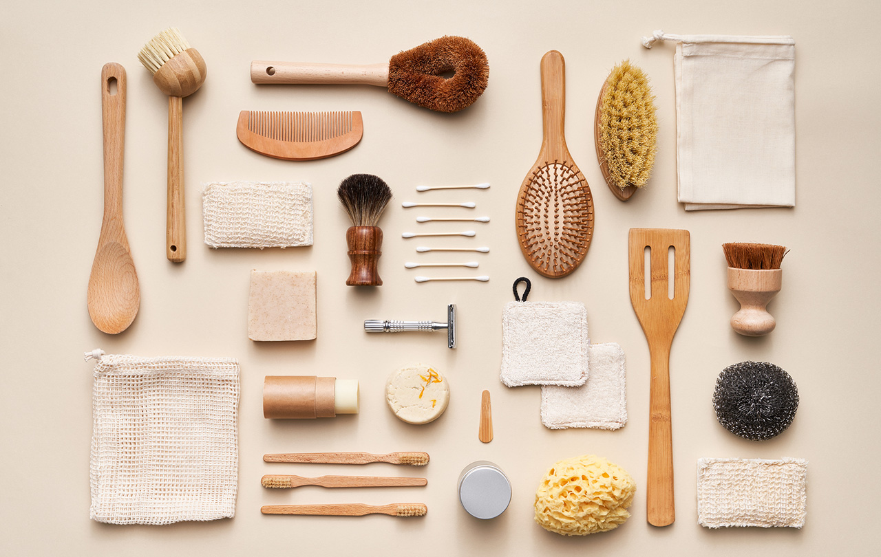 Coleção aérea de vários produtos cosméticos naturais e ferramentas reutilizáveis ​​de bambu colocadas em fundo bege